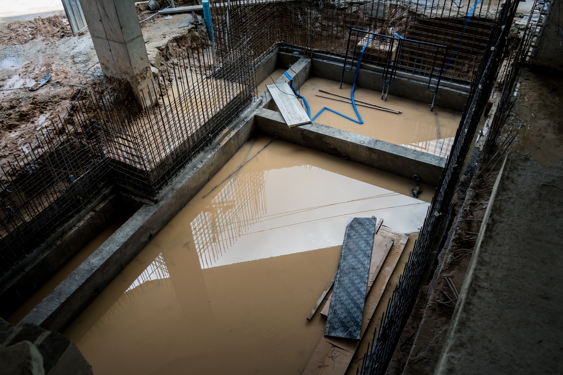 A construction site displaying a reinforced concrete foundation with steel rebar